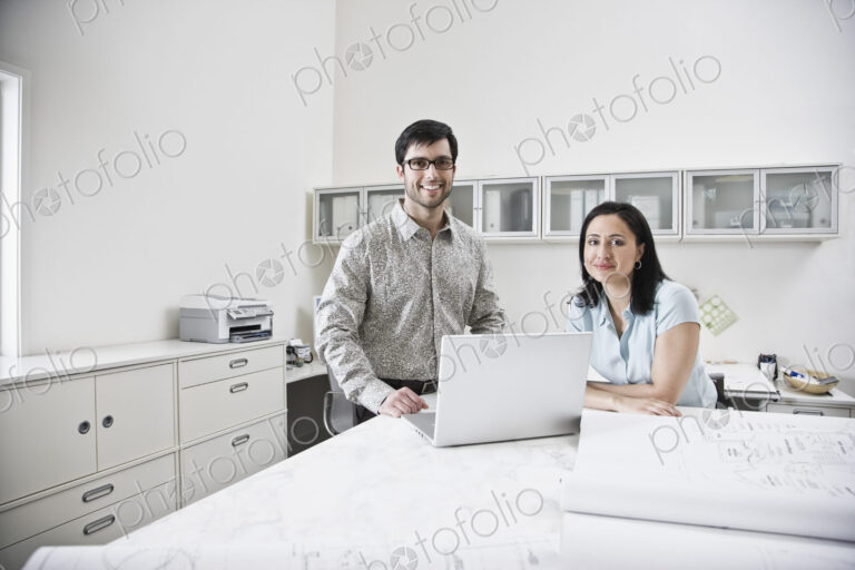 HIspanic man and woman working together in an architect's office.