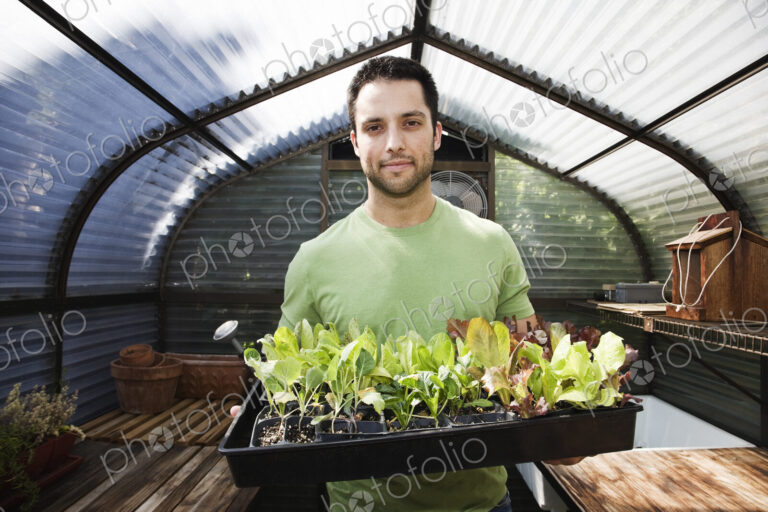 HIspanic man with new plants for the greenhouse.