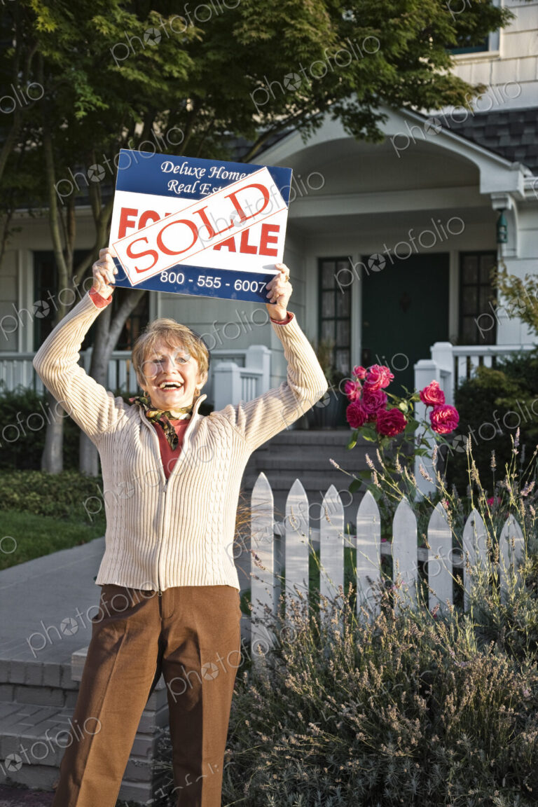 HIspanic seniors in front of their newly puchased remodeled older style home.