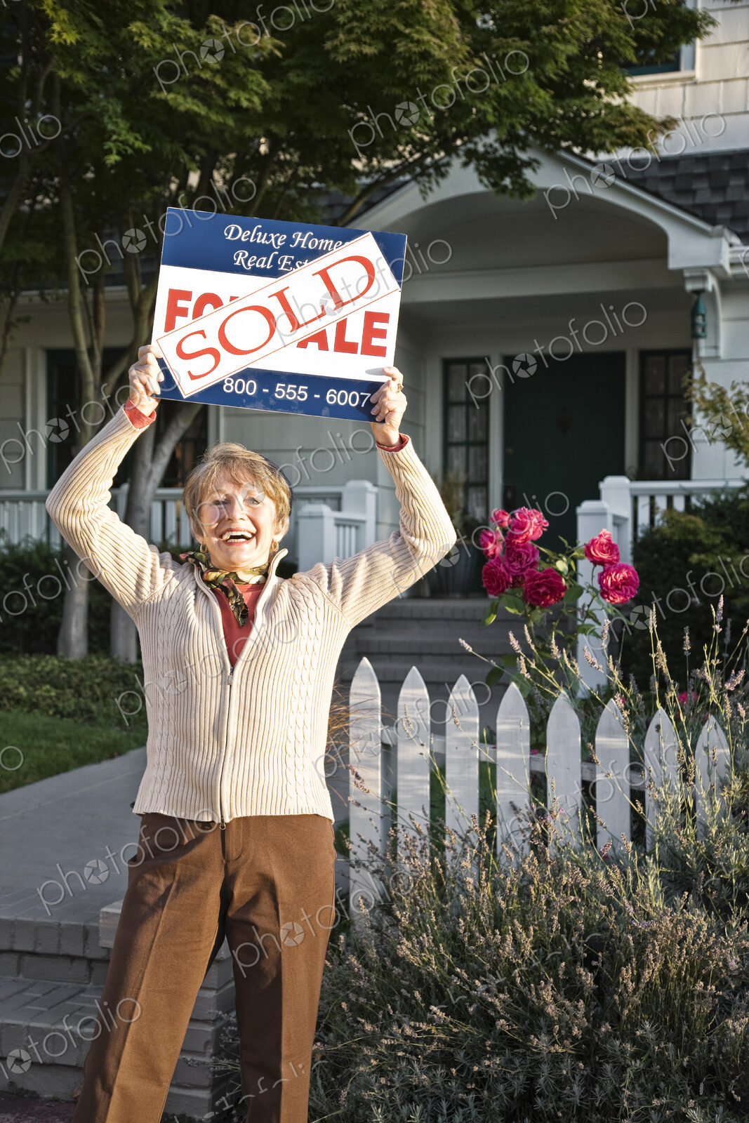 HIspanic seniors in front of their newly puchased remodeled older style home.