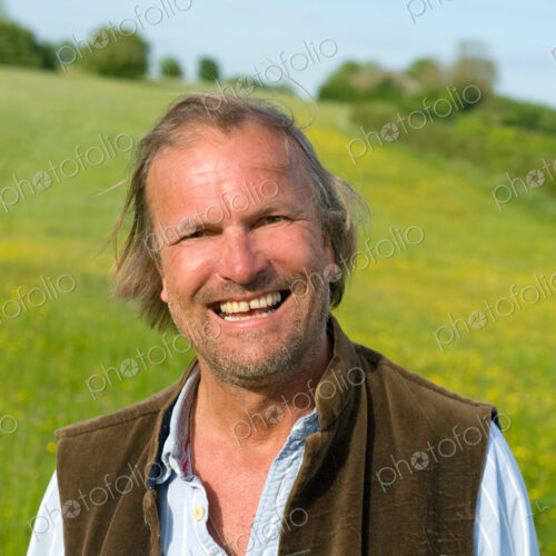 Half length portrait of mature man standing outdoors on a meadow, smiling at camera. Half length portrait of mature man standing outdoors on a meadow, smiling at camera.