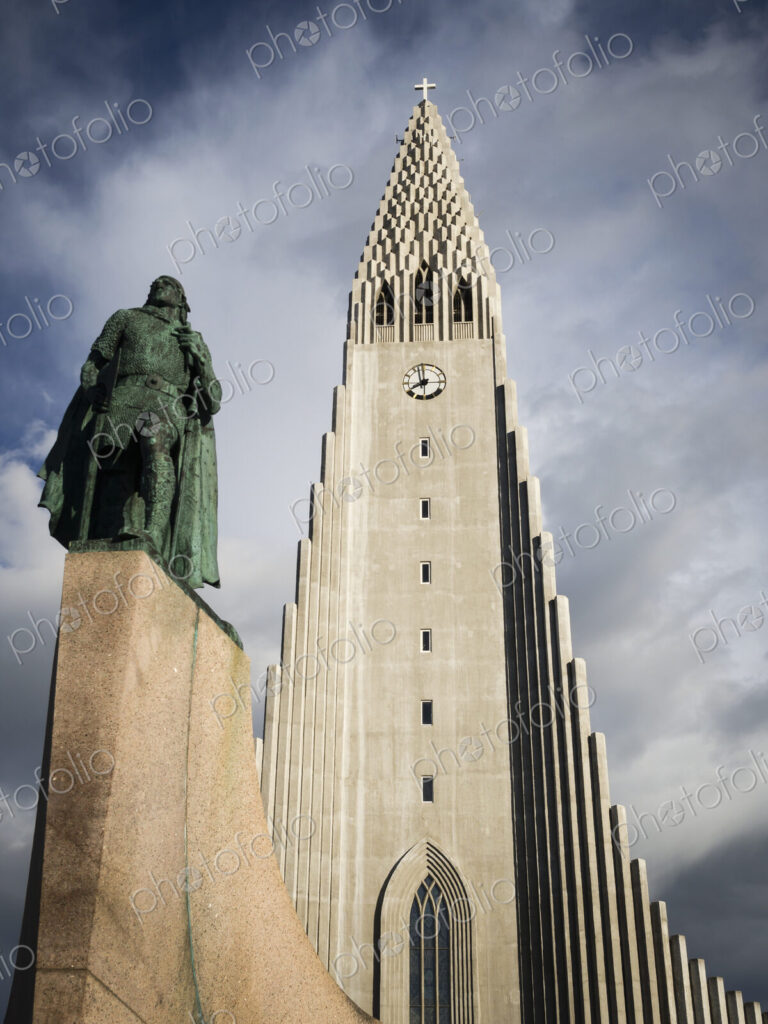 Hallgrímskirkja church, a tall modern church tower and statue of the explorer Leif…