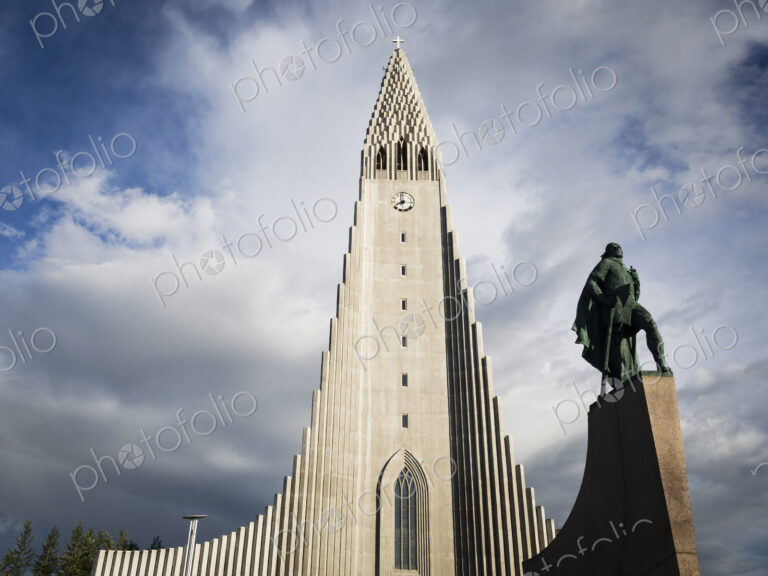 Hallgrímskirkja church, a tall modern church tower and statue of the explorer Leif…