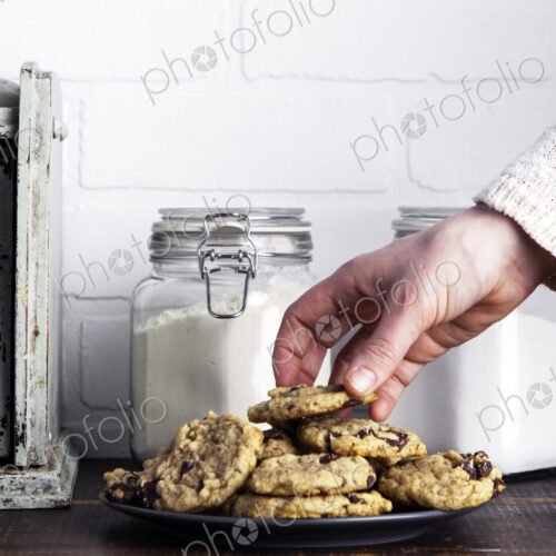 Hand taking cookie from plate Hand taking cookie from plate