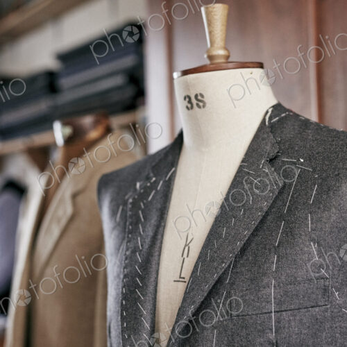 Handmade suit with stiching visible hanging on mannequin Handmade suit with stiching visible hanging on mannequin