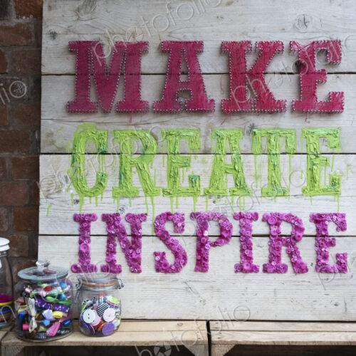 Handmade wooden sign with fabric letters in a workshop.