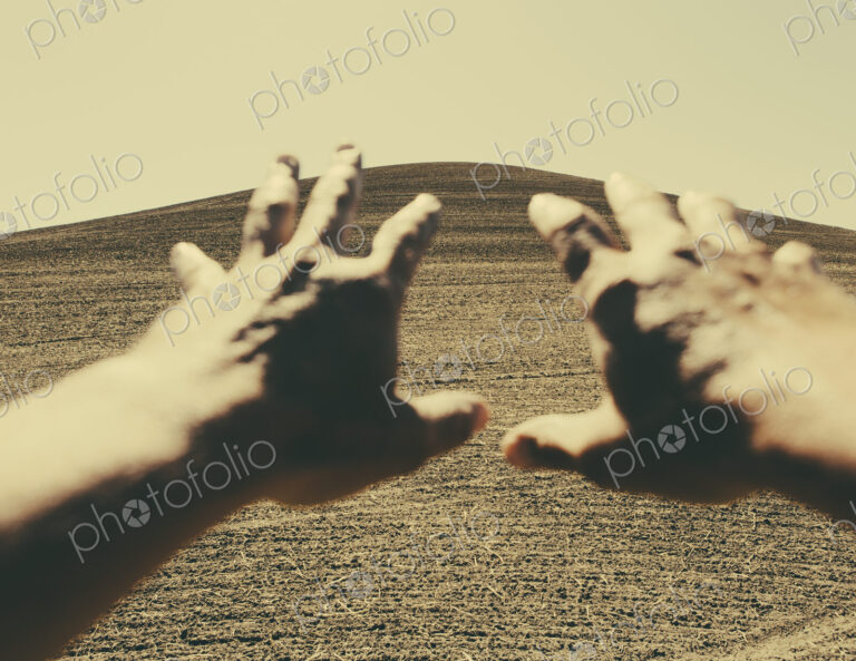 Hands extending reaching out towards ploughed farmland, near Pullman, Washington, USA