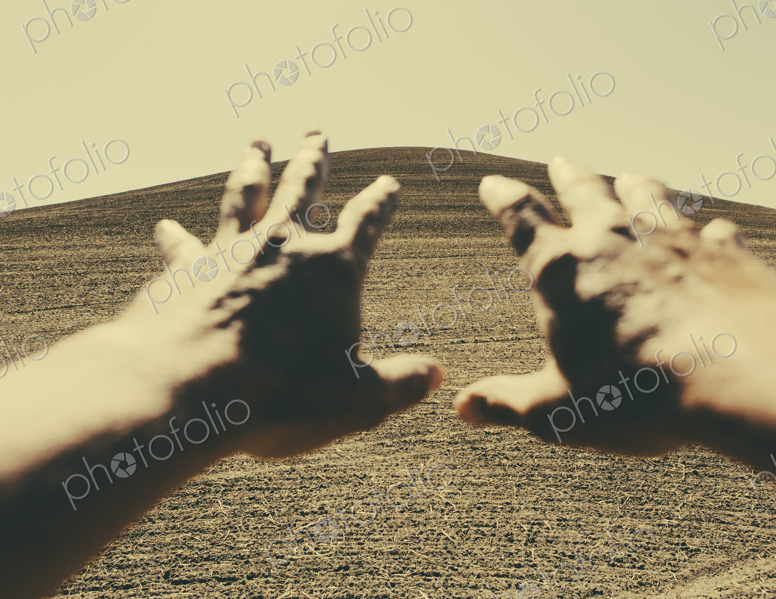 Hands extending reaching out towards ploughed farmland, near Pullman, Washington, USA