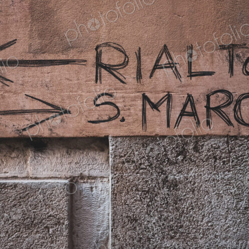Handwritten directions to the Rialto and San Marco on a wall in Venice, Veneto, Italy.