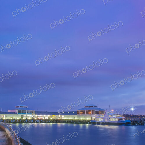Harbor and boat lit up at dusk