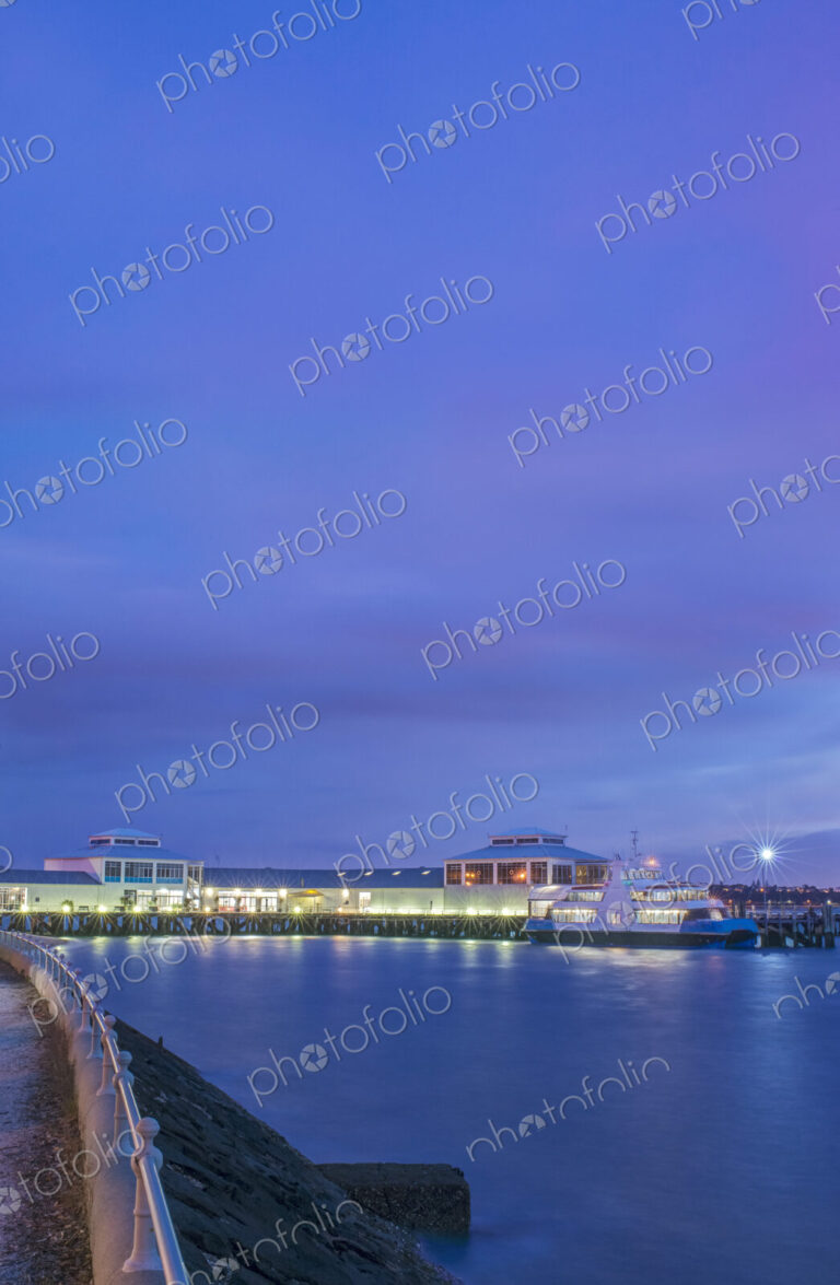 Harbor and boat lit up at dusk