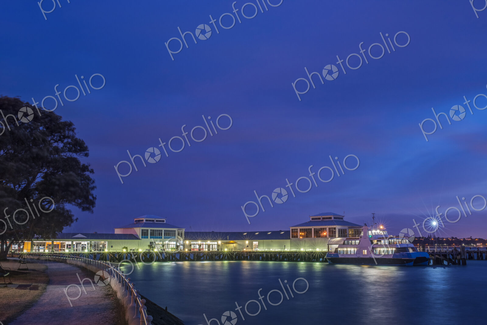 Harbor and boat lit up at dusk