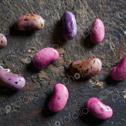 Harvested runner bean seeds, spaced out on a wooden surface, drying over winter.