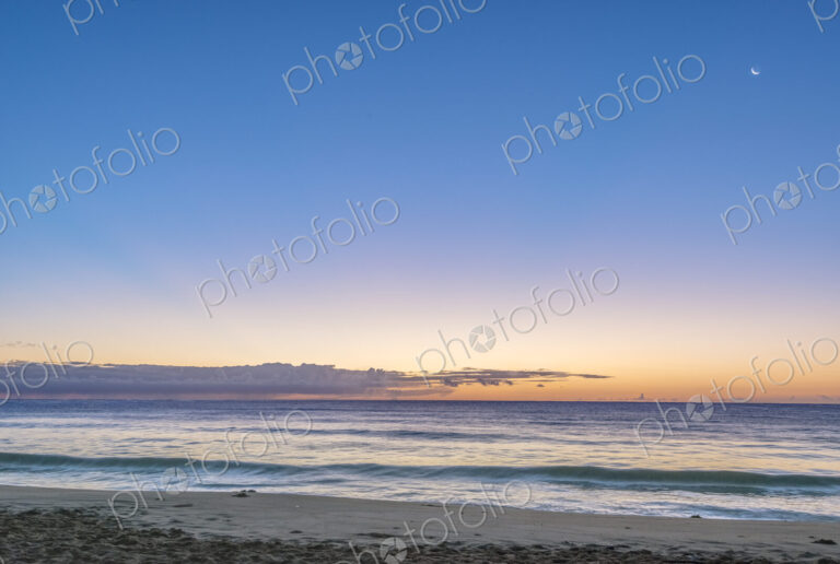 Hawaii, Kauai, Wailua Beach at dawn, the sun on the horizon, view out to sea.