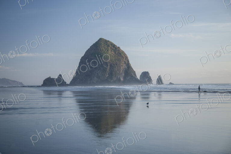 Haystack Rock reflecting in ocean, Cannon Beach, Oregon, United States