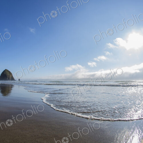 Haystack Rock reflecting in ocean waves, Cannon Beach, Oregon, United States Haystack Rock reflecting in ocean waves, Cannon Beach, Oregon, United States