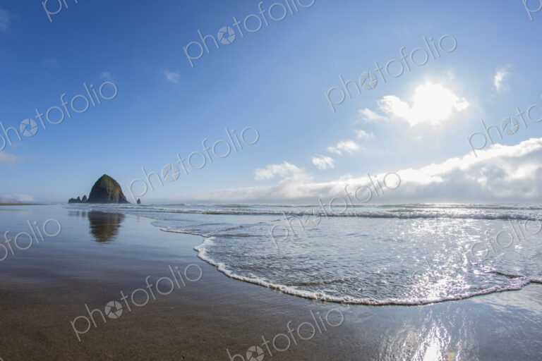 Haystack Rock reflecting in ocean waves, Cannon Beach, Oregon, United States
