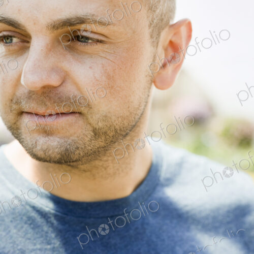 Head and shoulders portrait of a man with stubble in a blue teesirt. Head and shoulders portrait of a man with stubble in a blue teesirt.