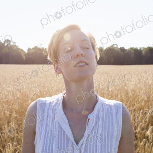 Head and shoulders portrait of a young woman standing in a cornfield. Head and shoulders portrait of a young woman standing in a cornfield.