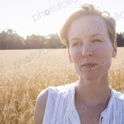 Head and shoulders portrait of a young woman standing in a cornfield. Head and shoulders portrait of a young woman standing in a cornfield.
