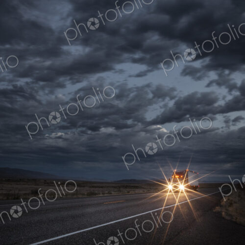 Headlights of a commercial truck on a highway late in the day. Headlights of a commercial truck on a highway late in the day.