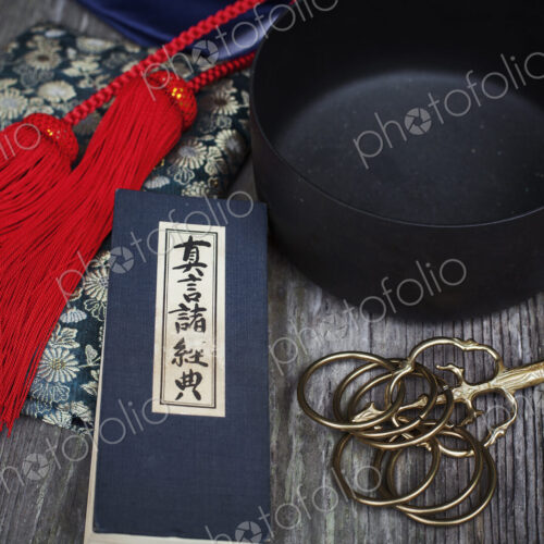 High angle close up of Buddhist prayer text, red silk tassel of a mala and black… High angle close up of Buddhist prayer text, red silk tassel of a mala and black…