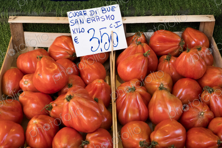 High angle close up of Cuore di Bue, beef tomatoes, at an Italian market stall.