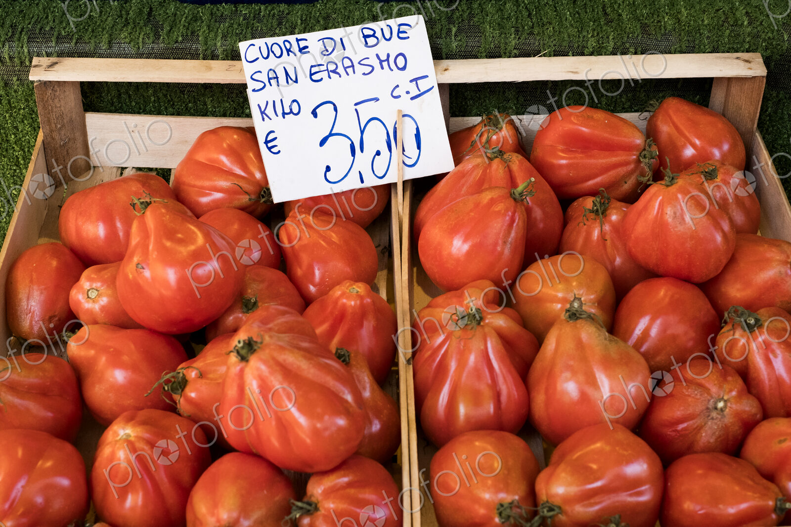 High angle close up of Cuore di Bue, beef tomatoes, at an Italian market stall.