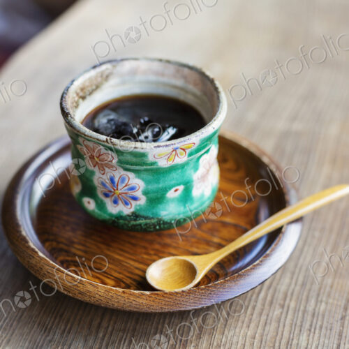 High angle close up of Japanese condiment in green bowl on wooden plate. High angle close up of Japanese condiment in green bowl on wooden plate.