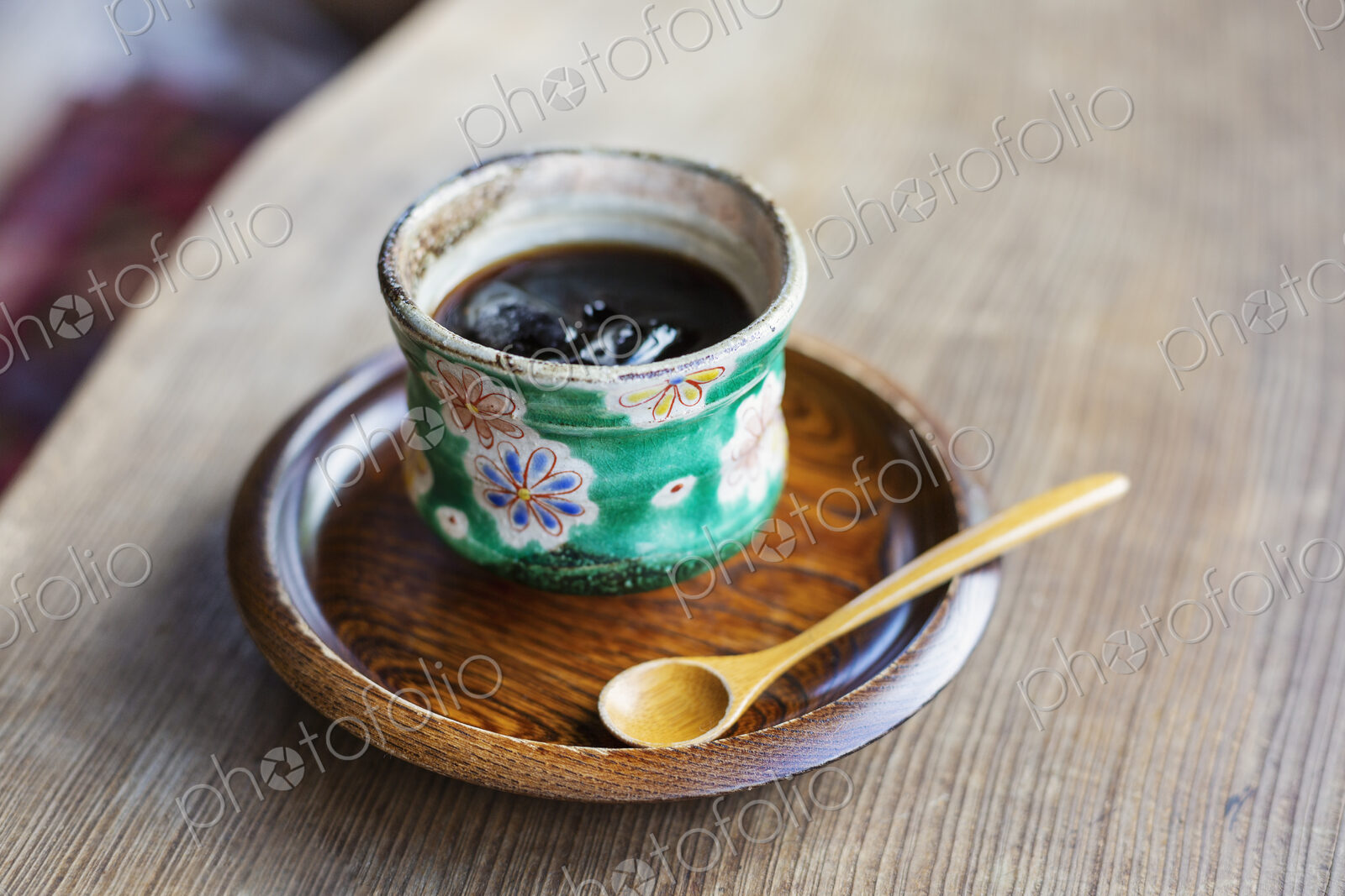 High angle close up of Japanese condiment in green bowl on wooden plate.