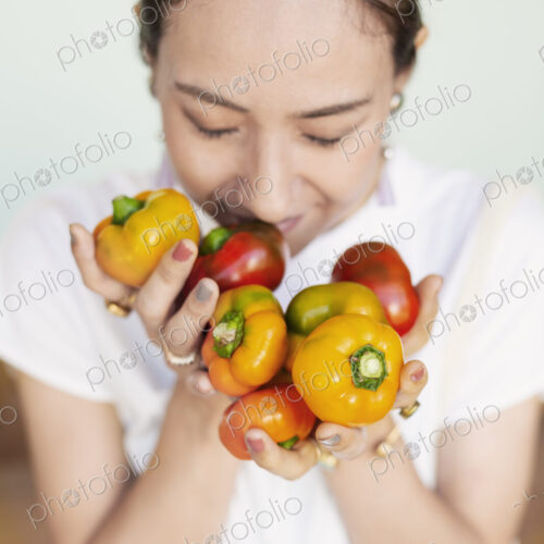 High angle close up of Japanese woman holding freshly picked picked red and yellow… High angle close up of Japanese woman holding freshly picked picked red and yellow…