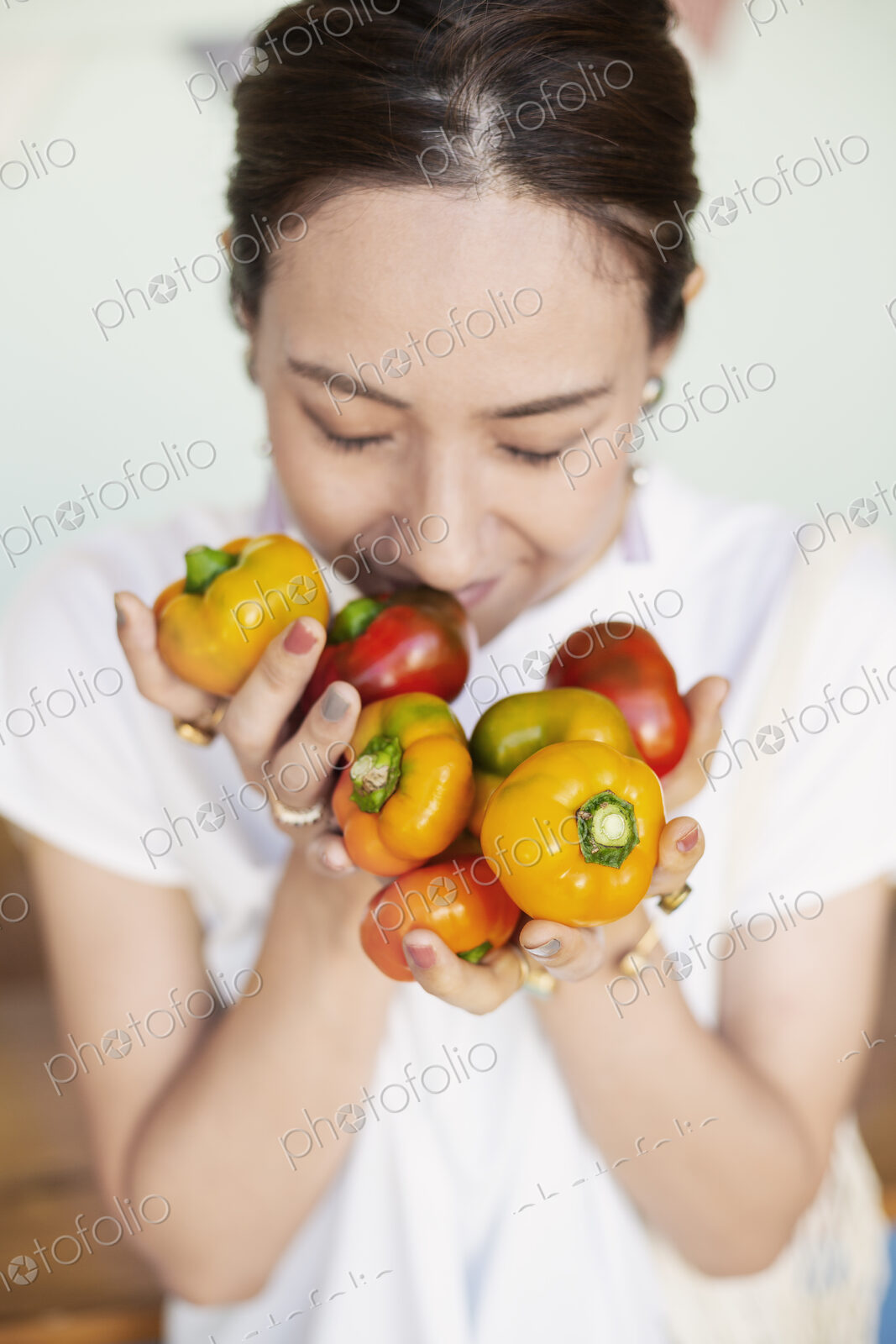 High angle close up of Japanese woman holding freshly picked picked red and yellow…