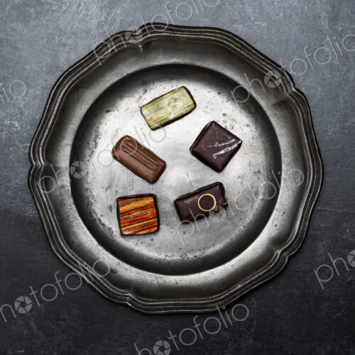 High angle close up of a selection of chocolate pralines on a tin plate on black… High angle close up of a selection of chocolate pralines on a tin plate on black…