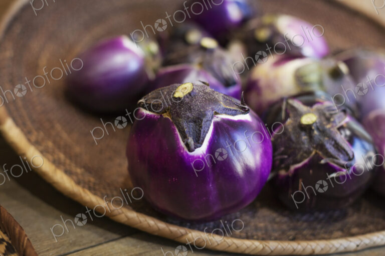 High angle close up of a selection of fresh purple aubergines in a farm shop.