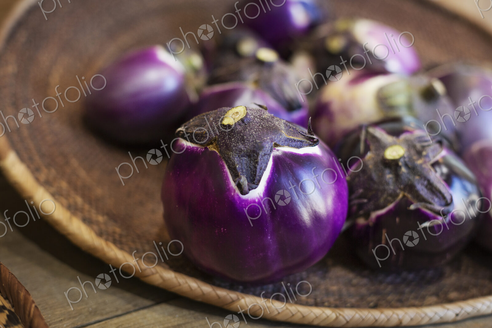 High angle close up of a selection of fresh purple aubergines in a farm shop.