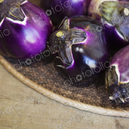 High angle close up of a selection of fresh purple aubergines in a farm shop. High angle close up of a selection of fresh purple aubergines in a farm shop.