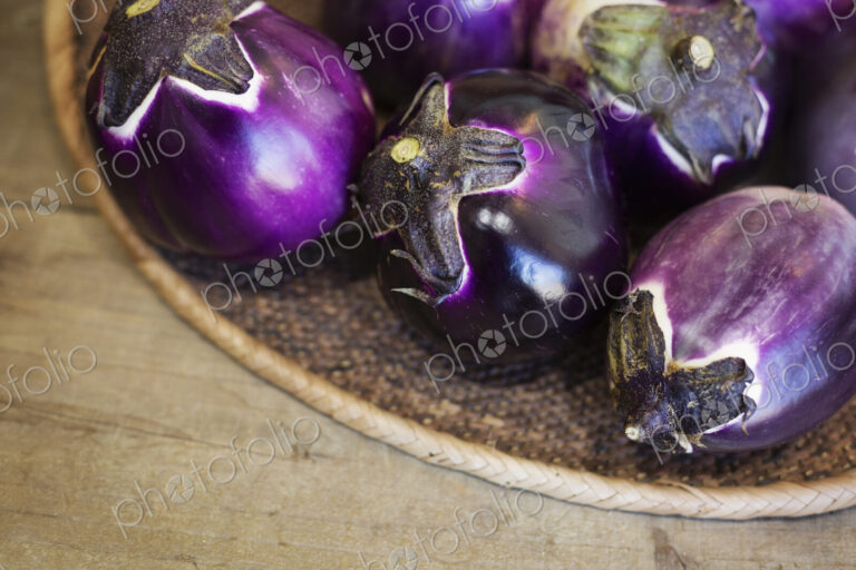 High angle close up of a selection of fresh purple aubergines in a farm shop.