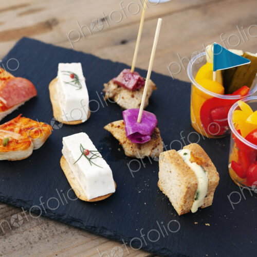 High angle close up of a selection of sandwiches and fresh vegetables on slate tray. High angle close up of a selection of sandwiches and fresh vegetables on slate tray.