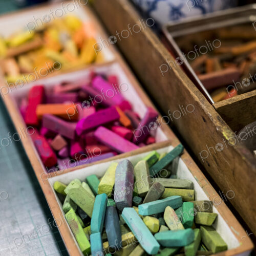 High angle close up of artist's crayons in a variety of vibrant colours.