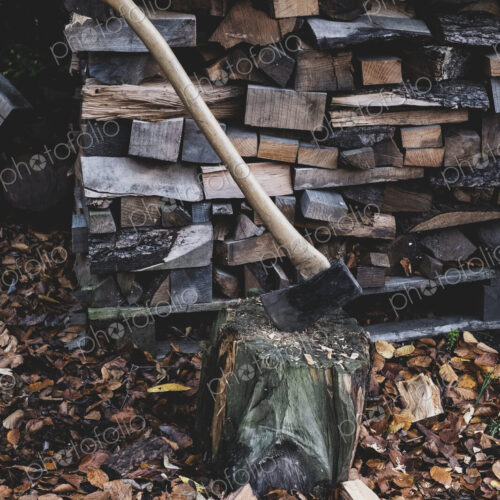 High angle close up of axe on chopping block, scattered wood cuttings and autumn leaves. High angle close up of axe on chopping block, scattered wood cuttings and autumn leaves.