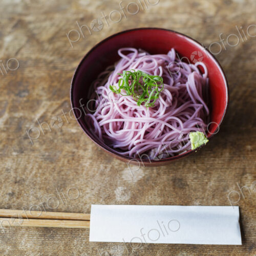 High angle close up of bowl of pink noodles on a table in Japanese restaurant. High angle close up of bowl of pink noodles on a table in Japanese restaurant.