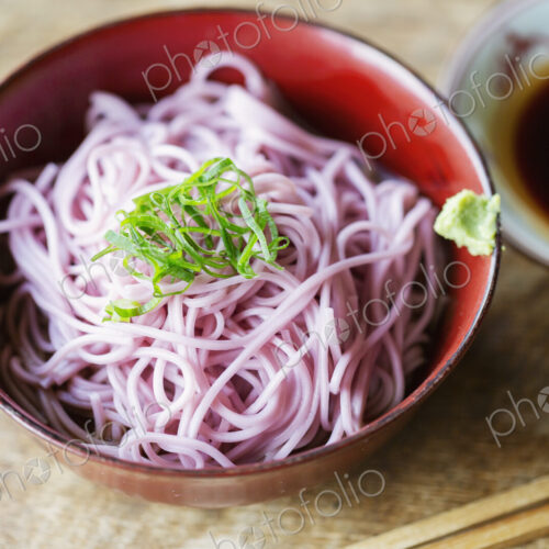 High angle close up of bowl of pink noodles on a table in Japanese restaurant. High angle close up of bowl of pink noodles on a table in Japanese restaurant.