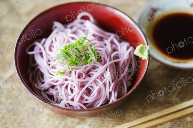 High angle close up of bowl of pink noodles on a table in Japanese restaurant.