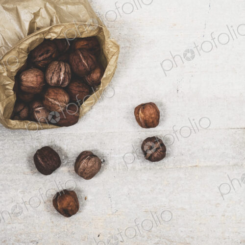 High angle close up of brown paper bag with fresh walnuts. High angle close up of brown paper bag with fresh walnuts.