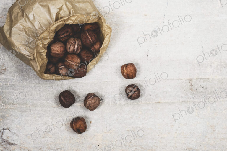 High angle close up of brown paper bag with fresh walnuts.
