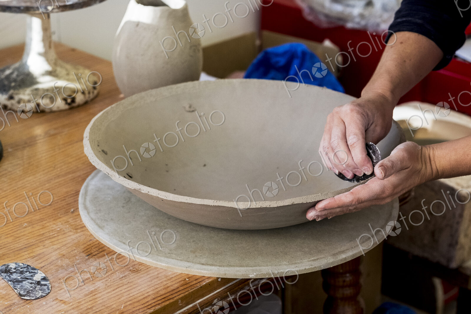 High angle close up of ceramic artist in her workshop, working on clay bowl.