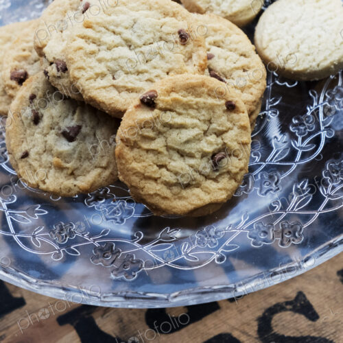 High angle close up of chocolate chip cookies on a glass plate.