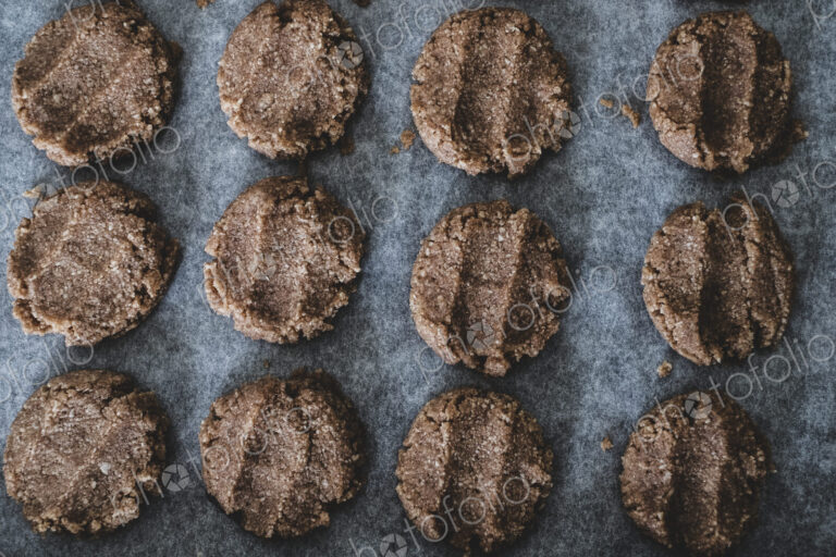 High angle close up of chocolate cookie dough on a baking tray.