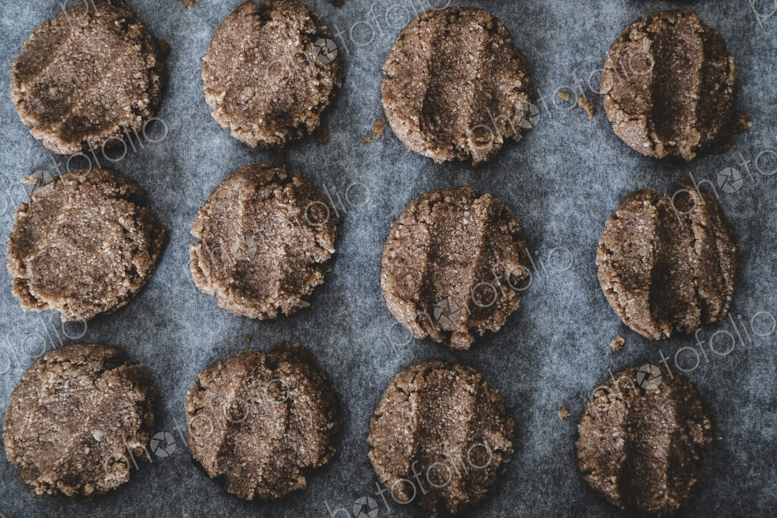 High angle close up of chocolate cookie dough on a baking tray.