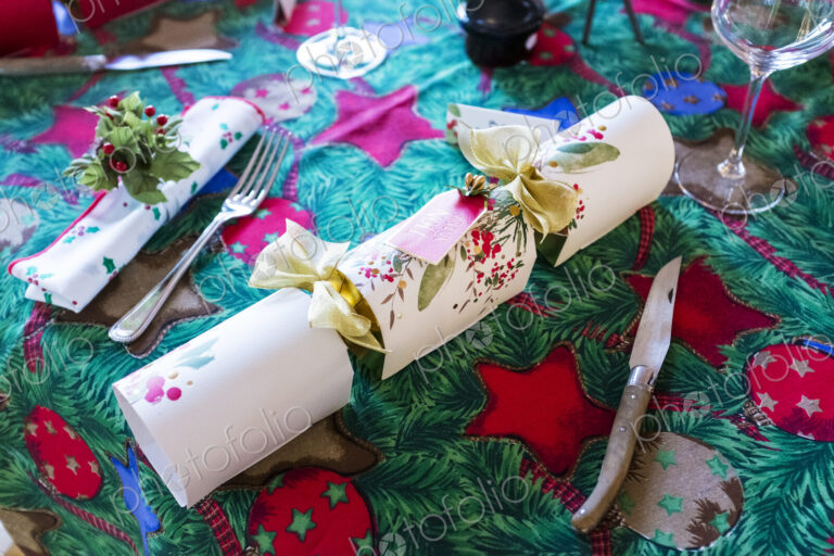 High angle close up of cutlery and white Christmas cracker, Christmas table setting